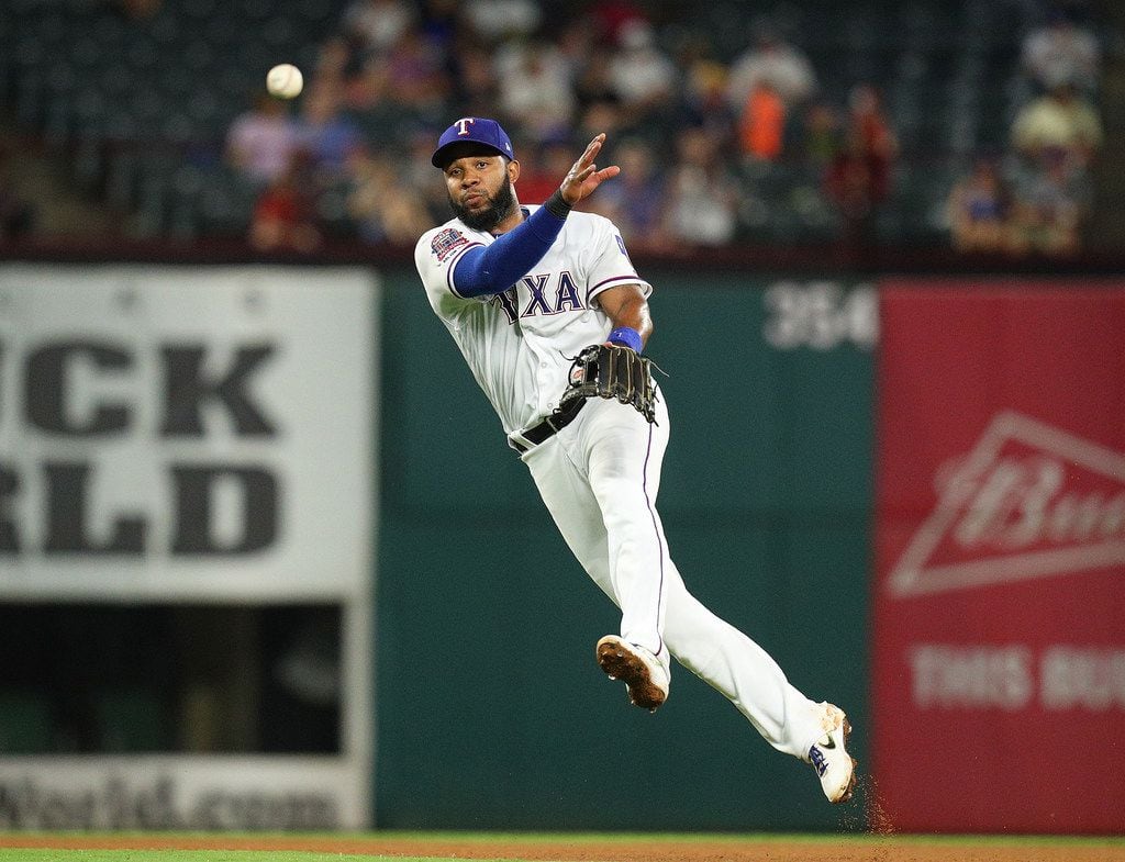 ARLINGTON, TEXAS - AUGUST 30: Elvis Andrus #1 of the Texas Rangers makes the throw to first...