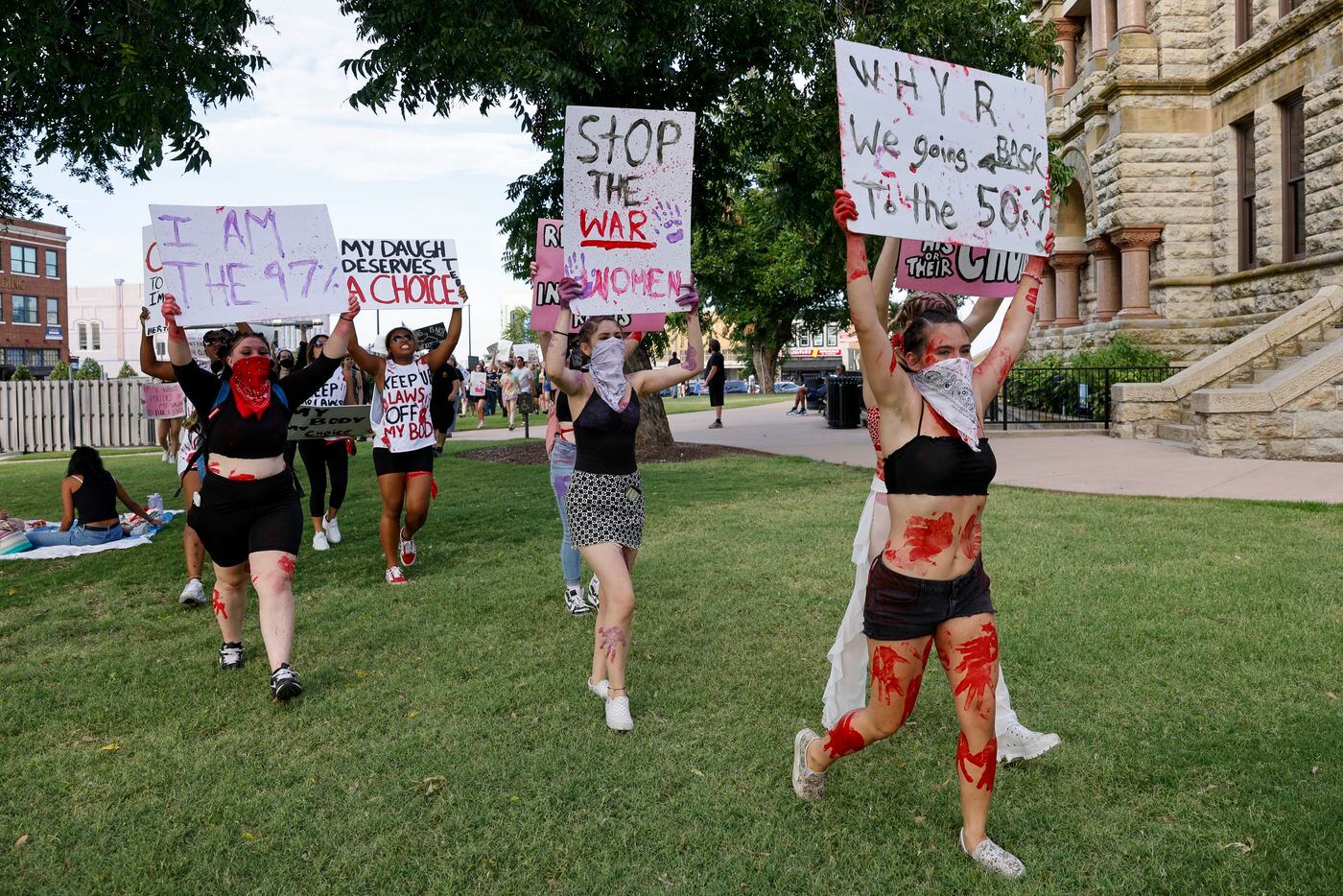 Abortion rights supporters march across the lawn at the old Denton County Courthouse during...