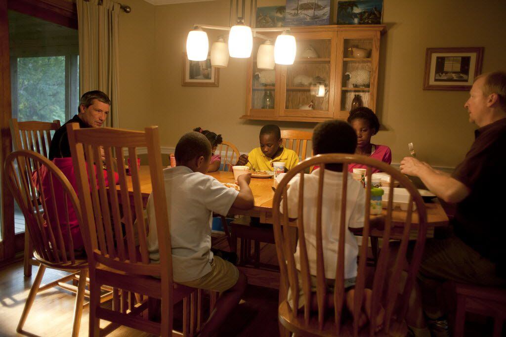 Matt Lees, left, and his partner, Ray, right, with some of their adopted children at dinner...
