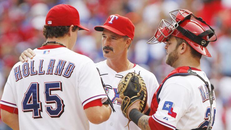 Texas pitching coach Mike Maddux talks with P Derek Holland in Game 2 of the American League...