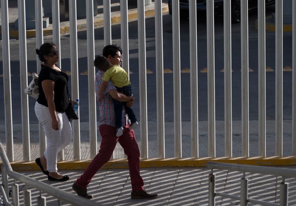 People cross from the Mexico side of the walking bridge between Hidalgo, Texas, and Reynosa,...