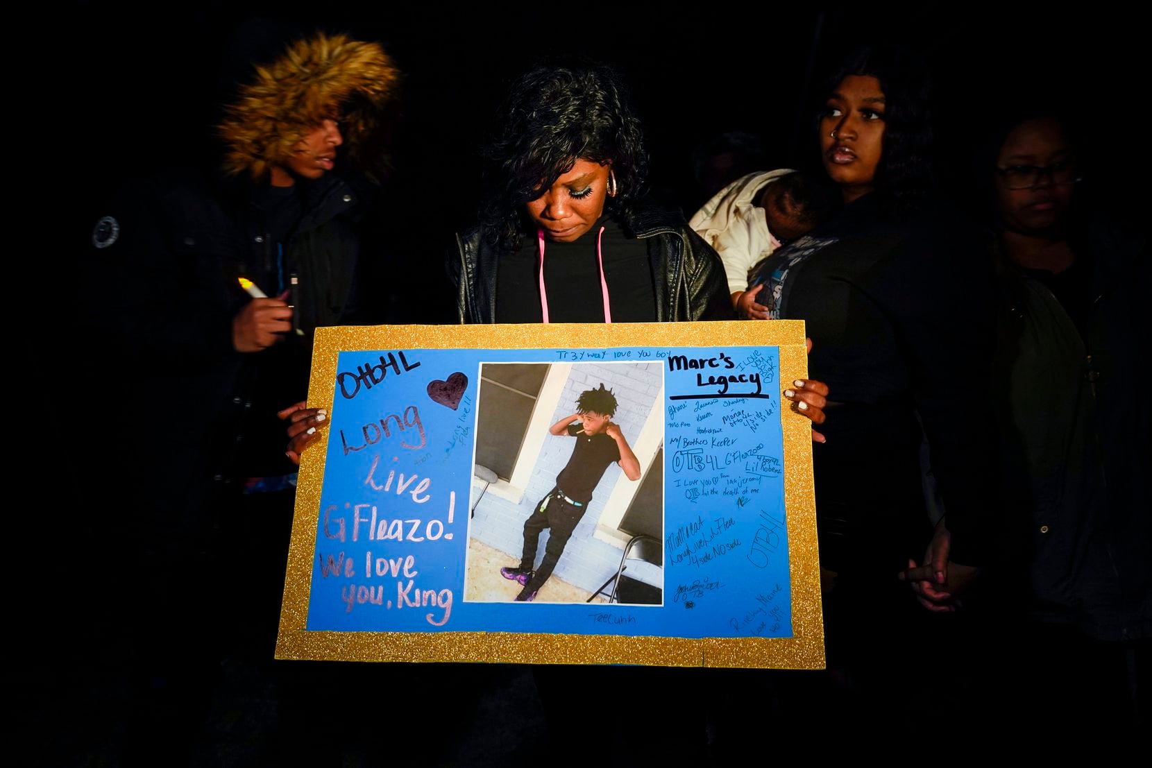 Monique Mitchell holds a photograph of her son Marc "Flea" Strickland, an 18-year-old victim of a shooting at Dallas ISD basketball game, during a vigil at Bushman Park on Sunday, Jan. 19, 2020.