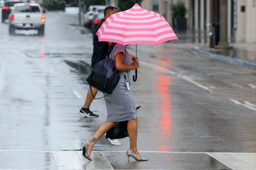 Una persona camina con un paraguas en el centro de Dallas, el martes 17 de agosto de 2021.