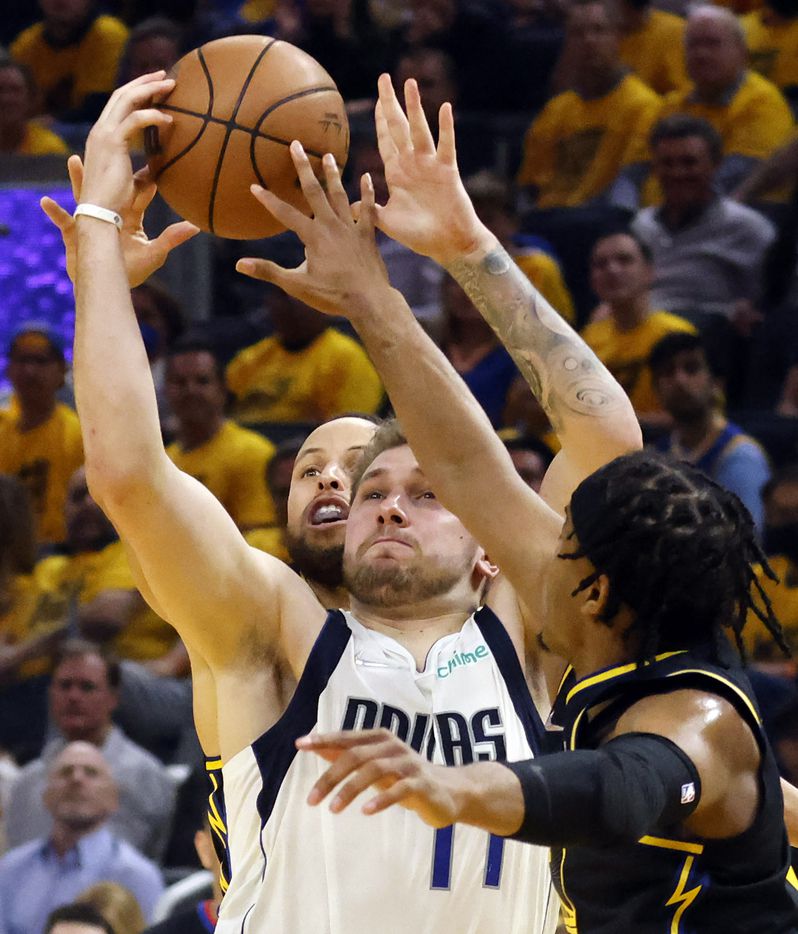 Dallas Mavericks guard Luka Doncic (77) drives between Golden State Warriors guard Stephen...