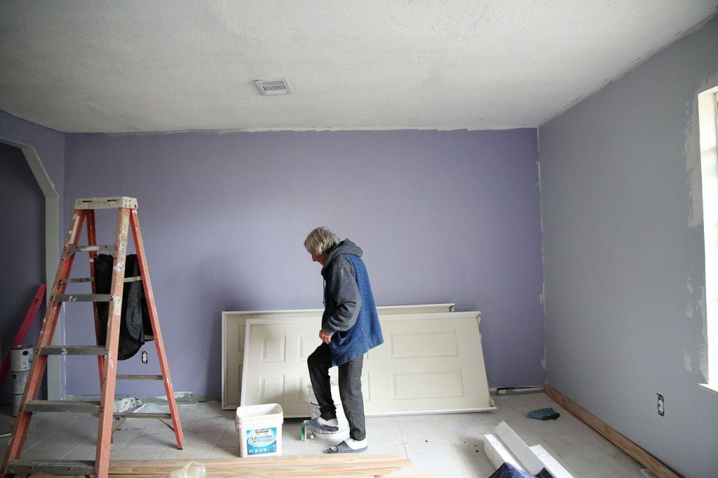Raul Cervantes walks across his living room in East Houston. The family recently moved back...