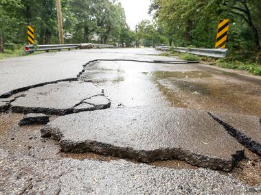 Damaged road remains by a flood-prone neighborhood in Balch Springs, a day after Dallas-Fort...