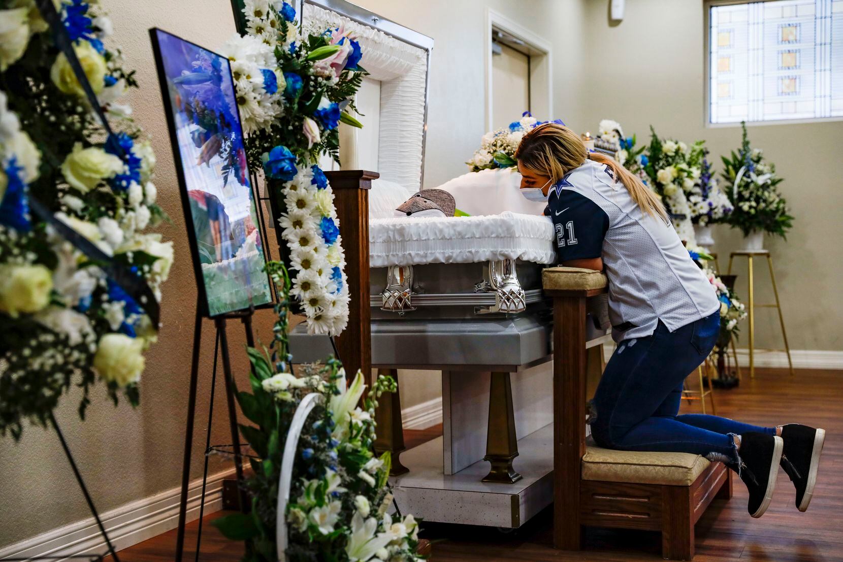 Lluneli Lopez kneeled by her son Xavier during a visitation service at Pilar Funeral Home in Garland on Wednesday, Dec. 29, 2021.