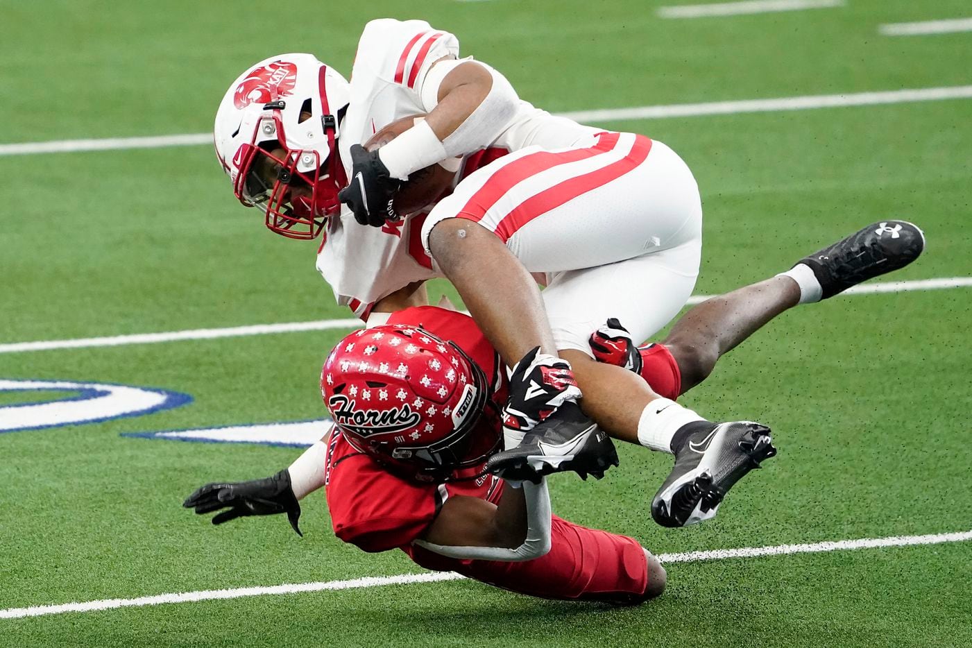 Katy running back Isaiah Smith (26) is knocked off his feet by Cedar Hill cornerback Amarian Williams (9) during the first half of the Class 6A Division II state football championship game at AT&T Stadium on Saturday, Jan. 16, 2021, in Arlington, Texas.