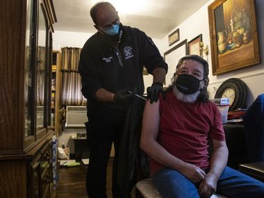 Firefighter II/EMT Steve Bowers (left) administers the first dose of the Moderna COVID-19 vaccine to Gilbert Muñoz at Muñoz’s home in Corpus Christi, Texas, on Monday, Feb. 1, 2021. The Corpus Christi Fire Department has spearheaded a program for administering COVID-19 vaccines to vulnerable elderly populations through utilizing existing rosters kept by the city’s Meals on Wheels initiative and those of other civil senior service programs. (Lynda M. González/The Dallas Morning News)