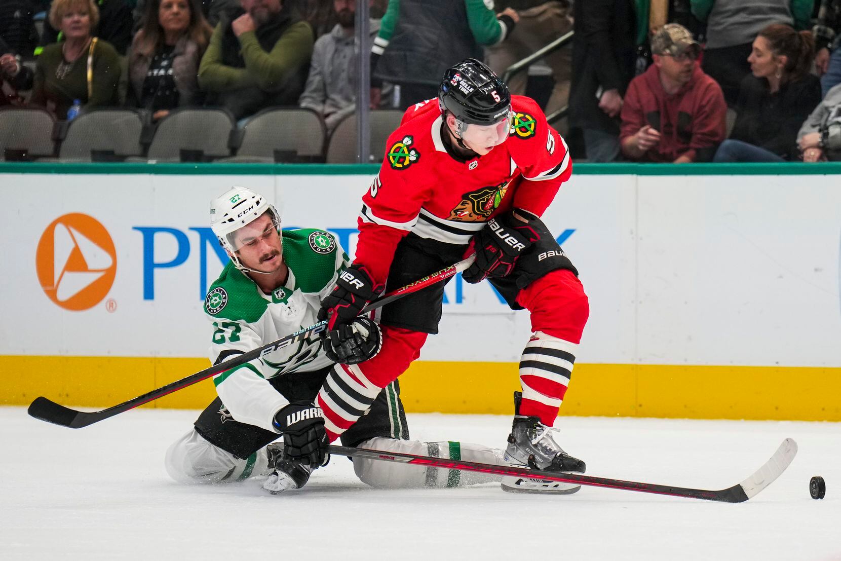 Dallas Stars left wing Mason Marchment (27) fights for the puck against Chicago Blackhawks...