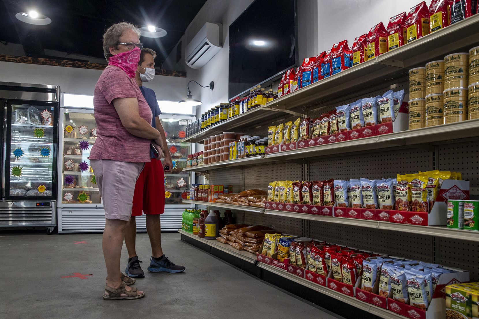 Cindy Brachey and her son, Tommy, peruse the market cajun convenience items kept in stock at T-Johnny's Seafood and Cajun Market in Colleyville, Texas, on Wednesday, July 8, 2020. 
