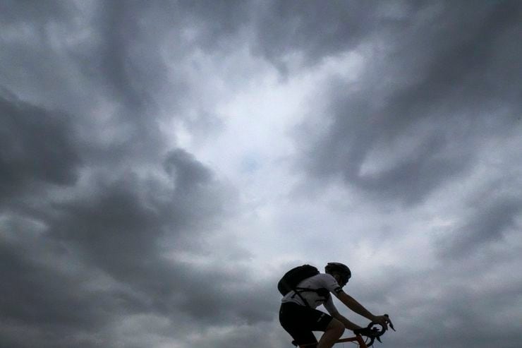 Storm clouds over a cyclist on North Airfield Drive near DFW International Airport on...