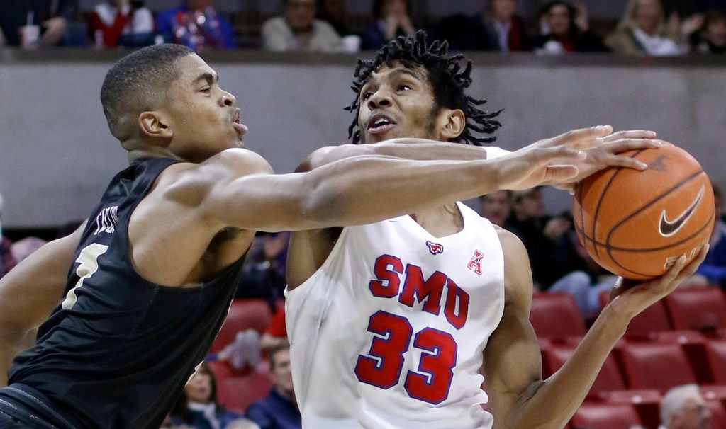 SMU guard Jimmy Whitt Jr. (33) drives strong to the basket against the aggressive defense of...