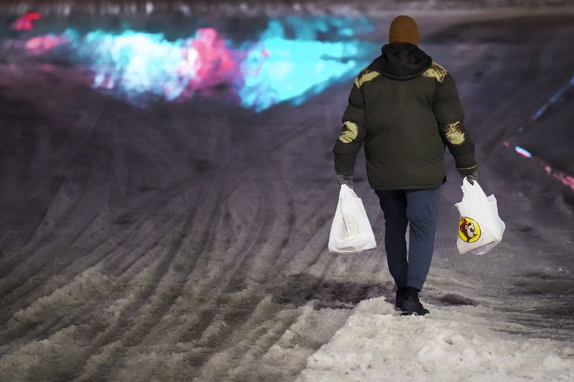 Un cliente camina sobre el hielo tras comprar en el Buc-ee's de Denton la noche del 31 de...
