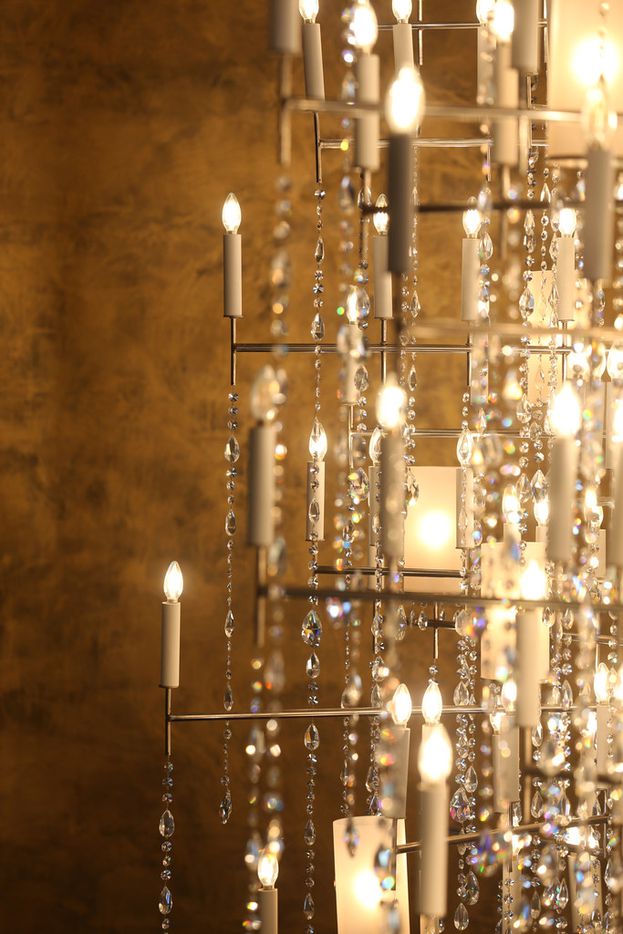 A chandelier against a gold wall inside Travis and Stephanie Hollman's home in Dallas on...