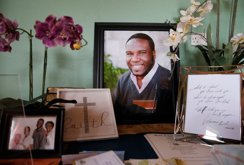 A photo of Botham Jean is displayed with cards and photos on one of the tables in his...