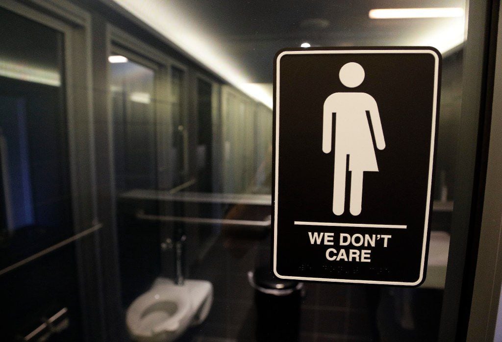 A sign on a restroom at 21c Museum Hotel in Durham, N.C., illuminates the hotel's policy....