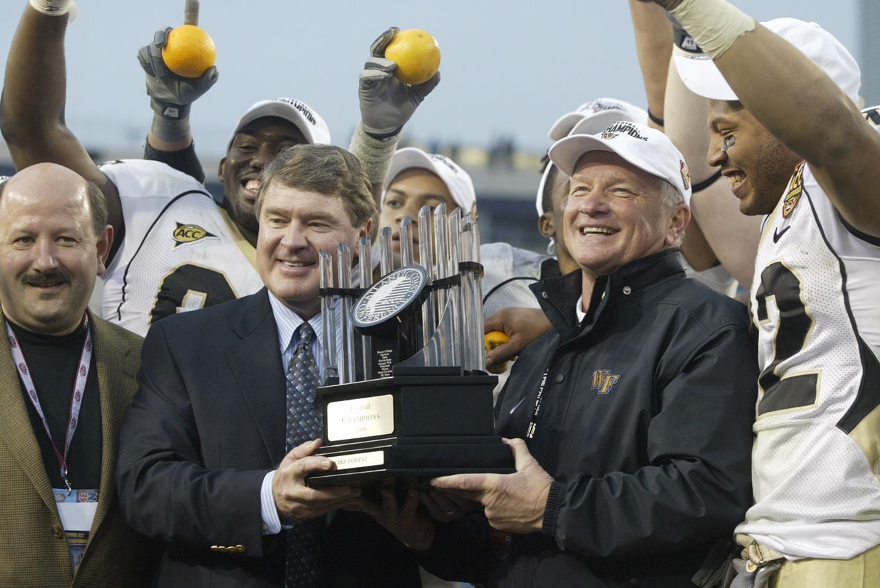 Baylor head coach Jim Grobe, pictured center right, received the ACC Championship trophy...