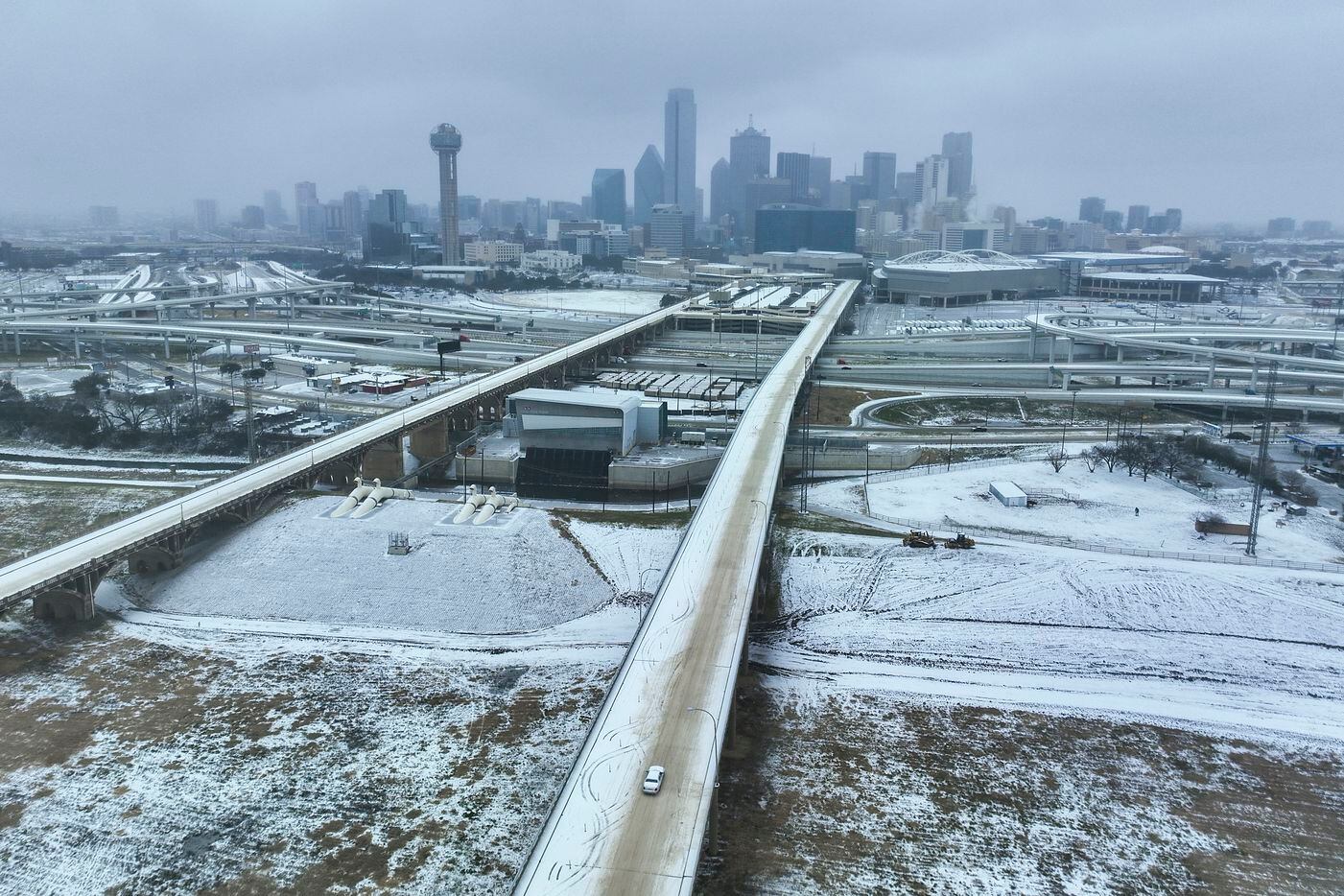 An icy mix covers the Jefferson Boulevard Viaduct as a car heads toward downtown from Oak...