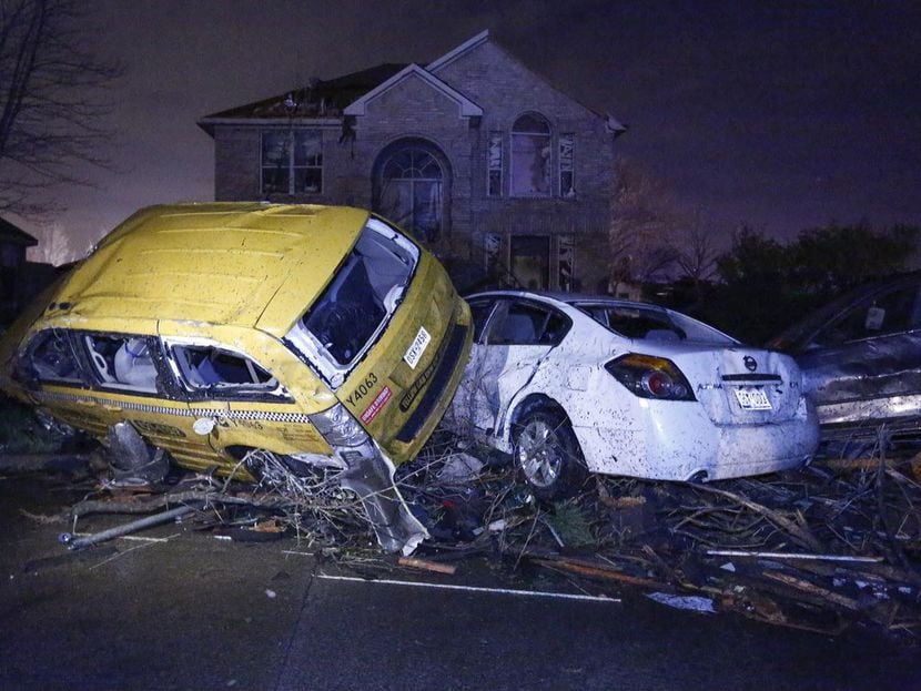 Autos apilados uno encima de otro como resultado de los tornados en un vecindario en el este...
