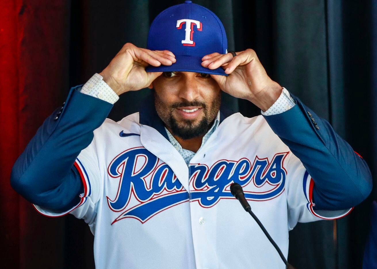Marcus Semien adjusts his Texas Rangers baseball hat at a news conference at Globe Life Park in Arlington on Wednesday, Dec. 1, 2021. Former Toronto Blue Jays, Marcus Semien, signed a contract with the Texas Rangers for 175 million dollars. (Rebecca Slezak/The Dallas Morning News)