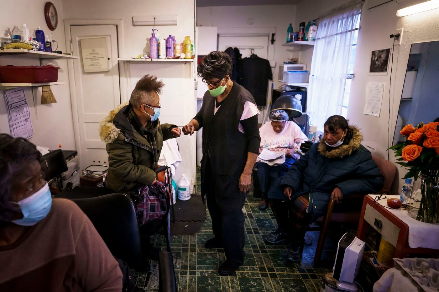 Earnestine Tarrant fist bumps with Sharon Curtis ay her hair salon in South Dallas on her final day.  “I can’t hug you, so we have to fist bump,” Tarrant said with a laugh, referring to the ongoing coronavirus pandemic.