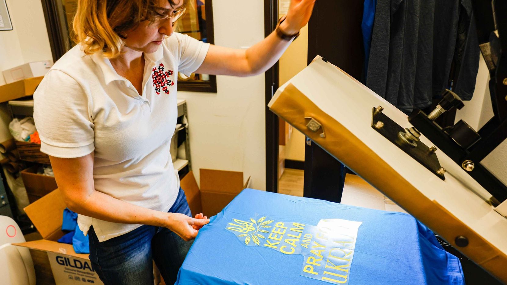 Store owner Olena Jacobs, works on t-shirts in support of Ukraine throughout the day at Ukie...