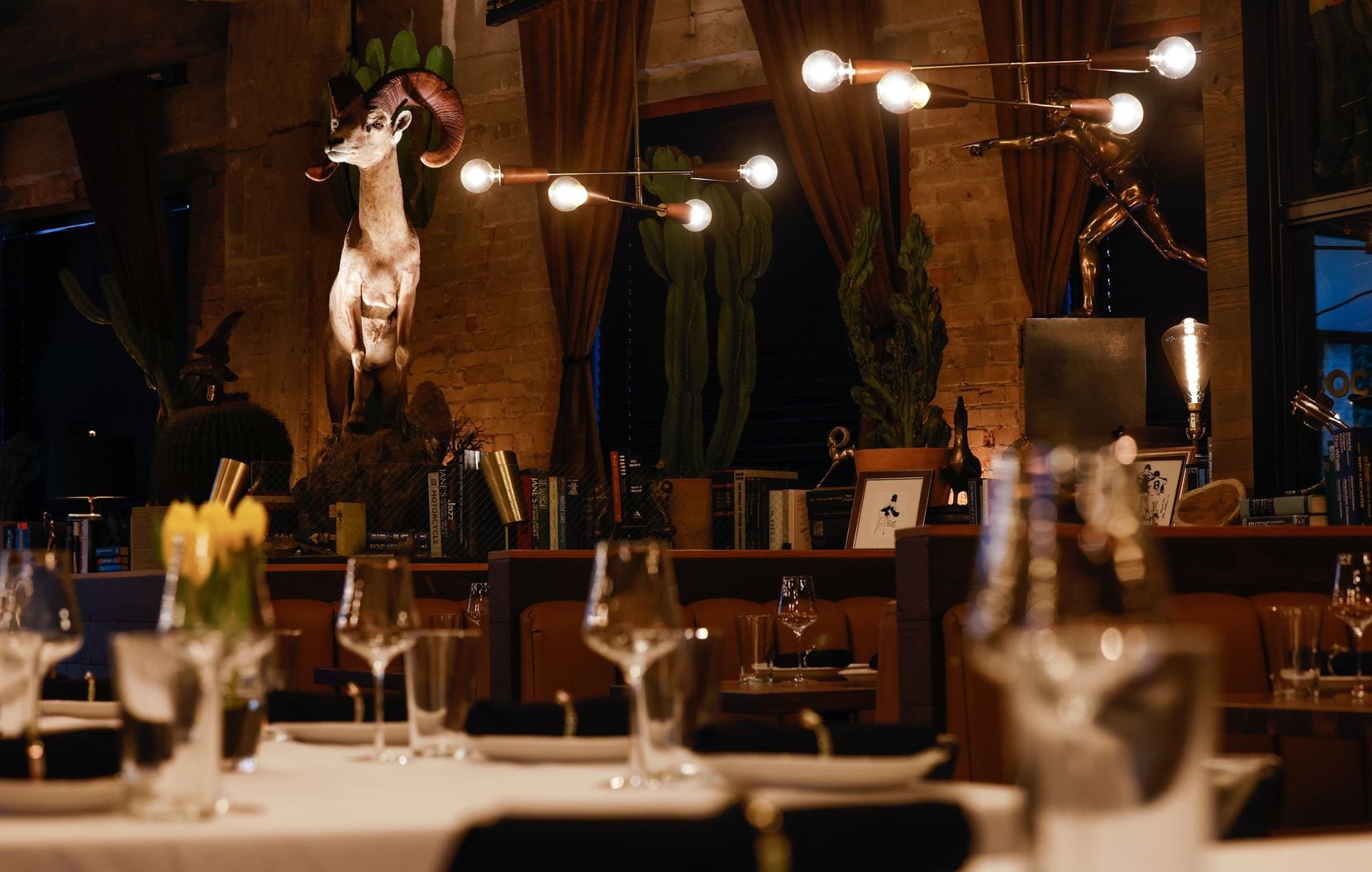 The dining room at prime rib restaurant Brass Ram is moody, with brass statues, books and...