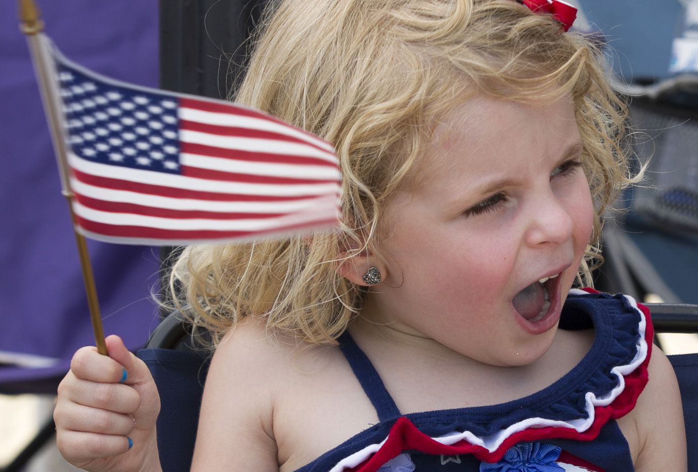Katie Shearer, 4, of Arlington waves her flag as she watches the Arlington Fourth of July...