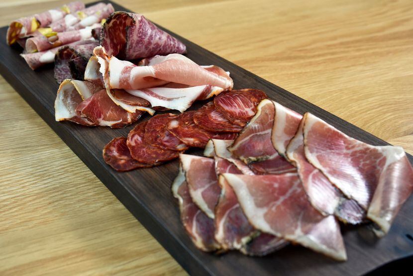 A chef's choice charcuterie board includes, from front to back, speck, ventricina vastese,...
