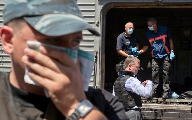 
A man covered his face with a rag Monday near a refrigerated train in Torez, Ukraine, as a...