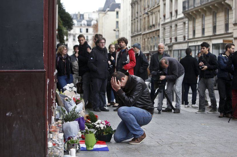 Un hombre llora frente al Carillon Café, en París, uno de los sitios de los atentados de la...