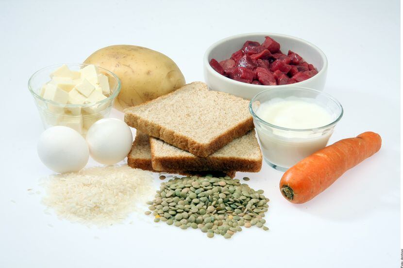 Una foto de diferentes alimentos: mantequilla, huevos, pan, zanahoria, leche, verduras.