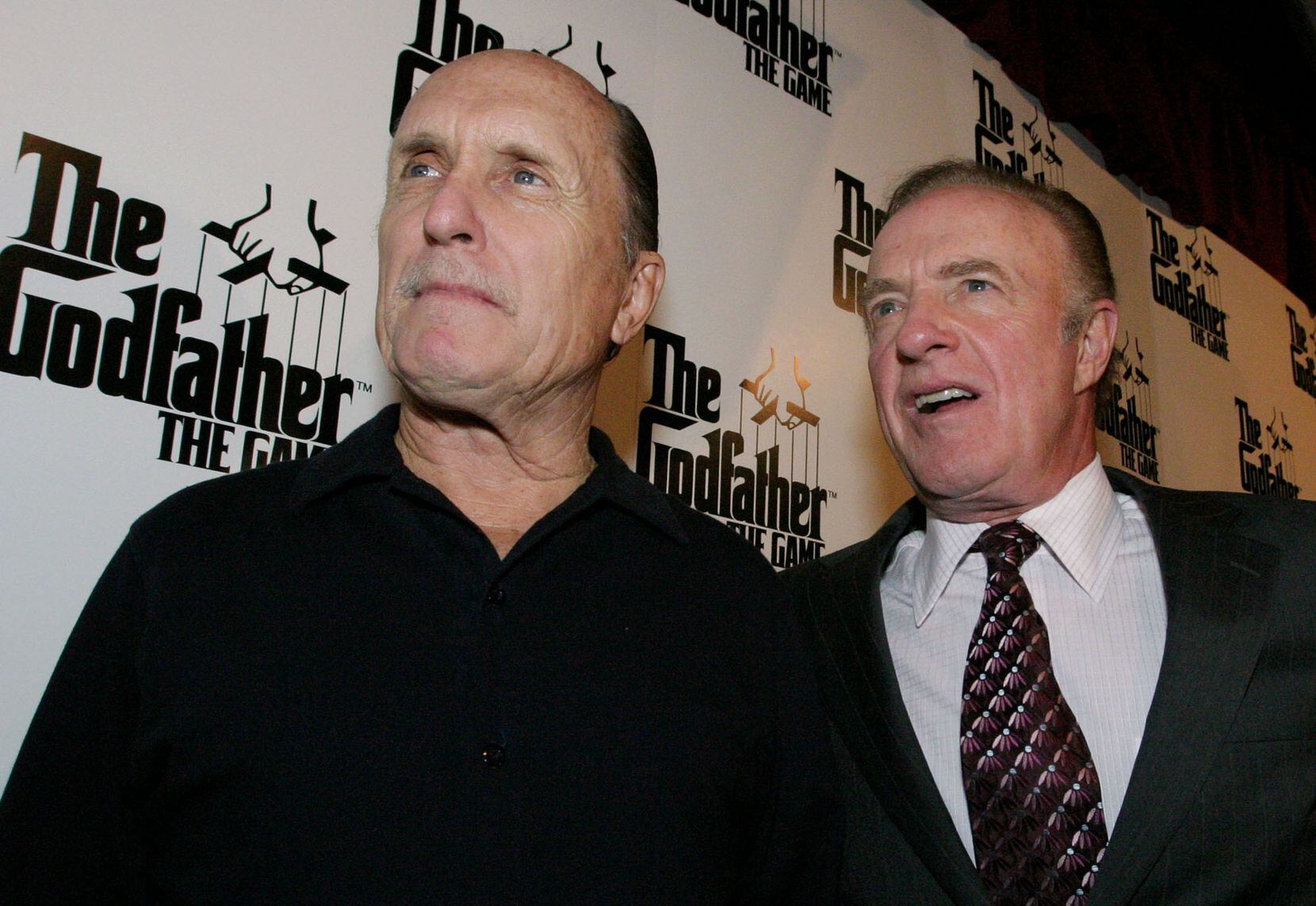 Robert Duvall, left, and James Caan pose for photographers as they arrive at EA Games'...