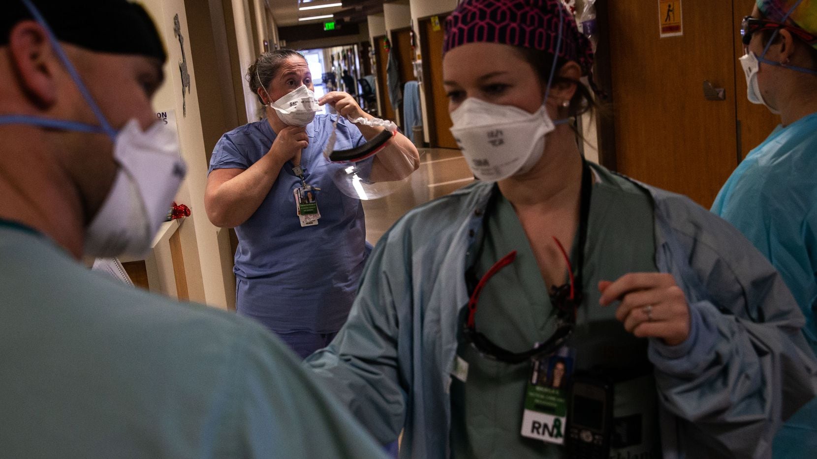 Samantha Rowley (center) suits up with personal protective equipment to help with a...