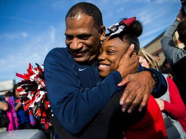 Kevin MaBone hugs cheerleader Aniya Sentell, 13, as he is surprised with a car during a...