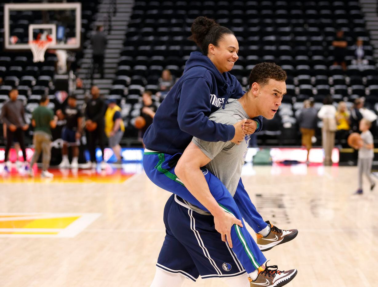 Dallas Mavericks assistant coach Kristi Toliver hops on the back of Dallas Mavericks center...