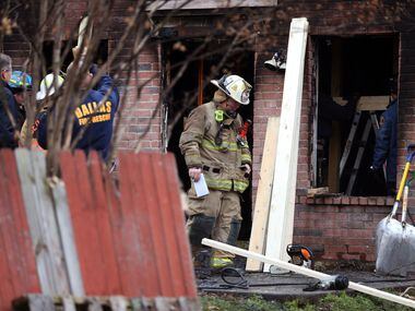 Dallas and Cedar Hill fire-rescue workers reinforce a house that caught fire early Thursday...
