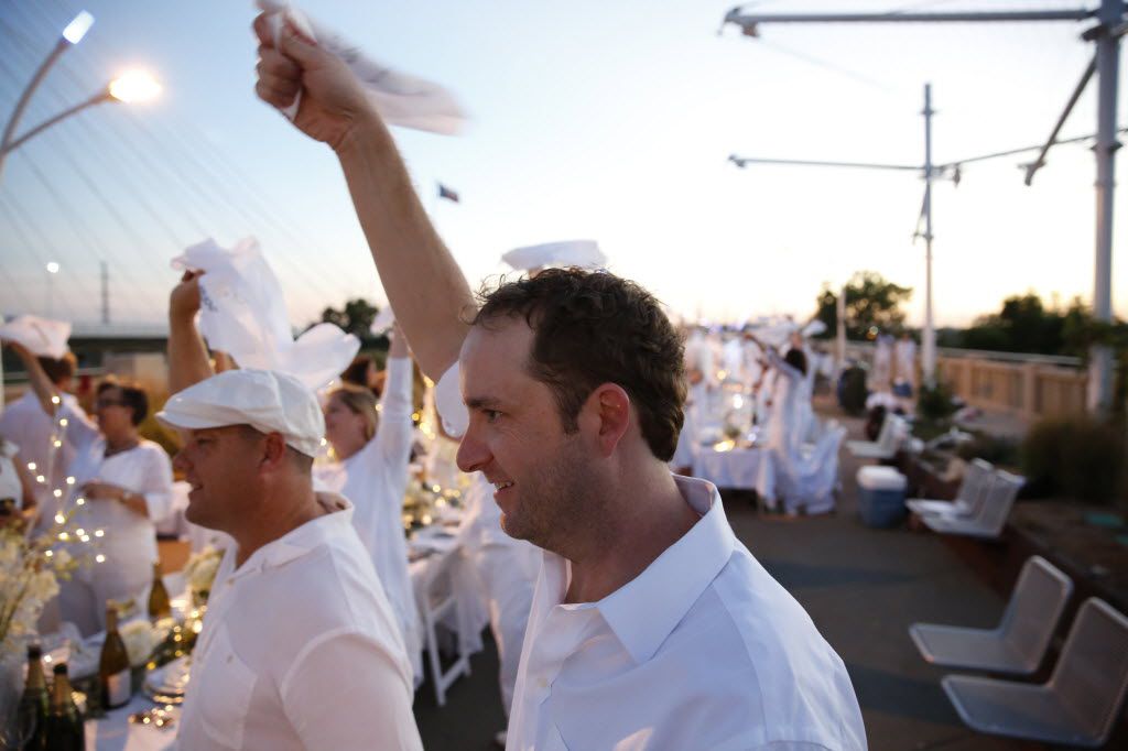 Ben Millice waves his napkin to signal dinner time during the inaugural Diner en Blanc...