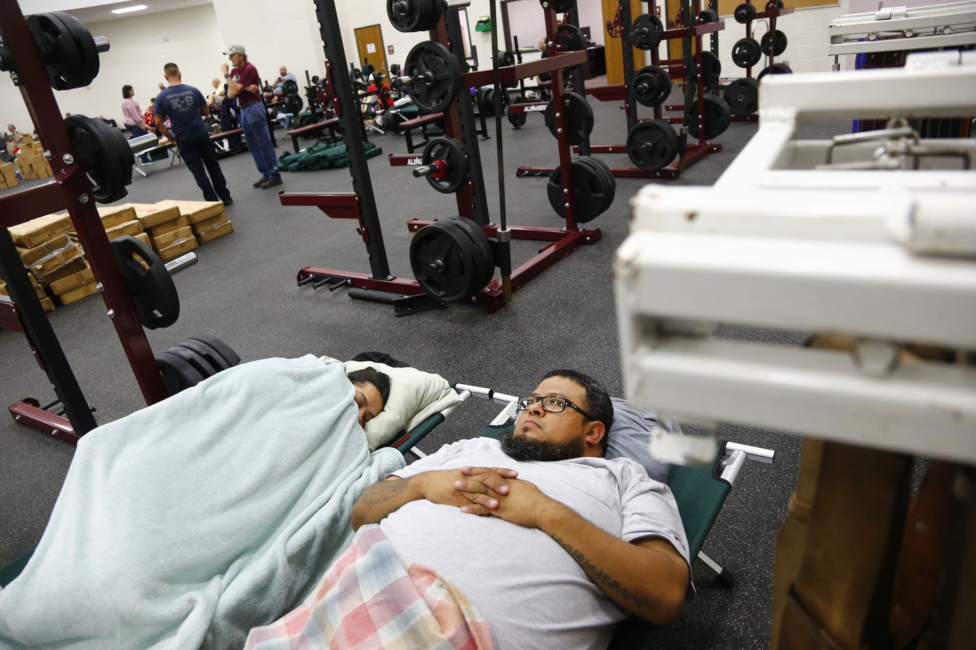 Simon and Stephanie Figueroa sleep in cots in the FEMA dome at Cal Allen High School which...