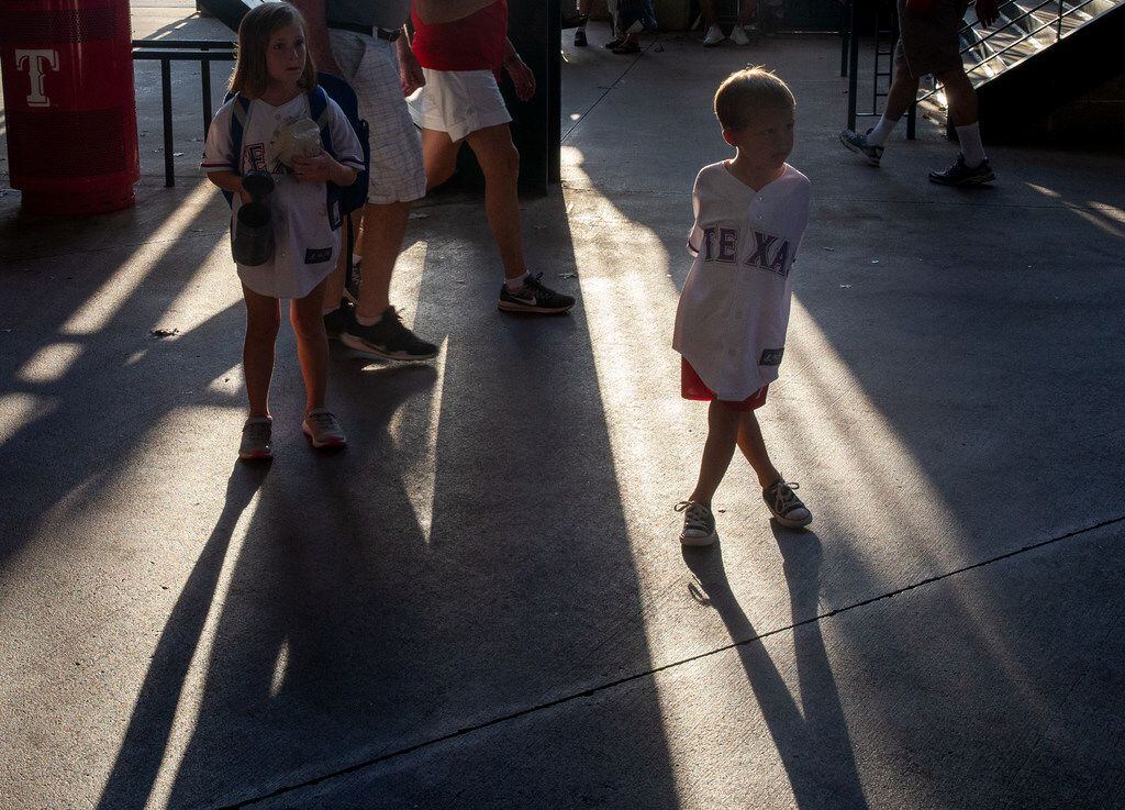 Henry Wilson (right), 4, and Reese Wilson, 7, wait near the exit of Globe Life Park...