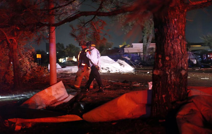 A pair of firefighters inspect the damage after the roofs of The Mirage Apartments complex...