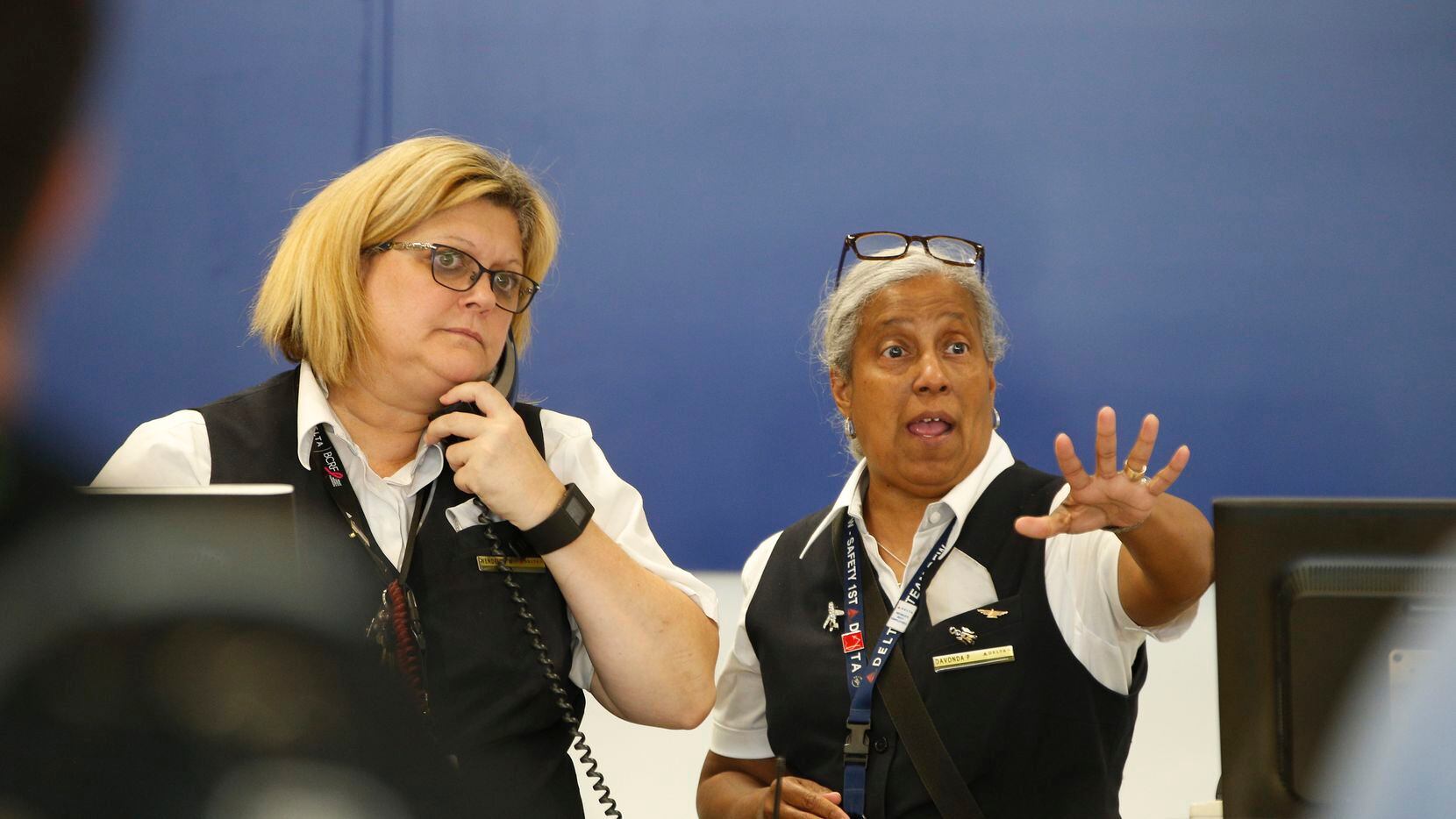 Delta workers check in passengers at DFW International Airport today after a power outage in...