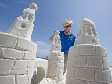 Casey Fabianski with Beach Sand Sculptures puts the finishing touches on a sand castle at the beach in Destin, Florida on Wednesday, June 11, 2014. (AP Photo/Northwest Florida Daily News, Devon Ravine)