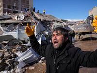 A man reacts, after rescue teams found his father dead under a collapsed building, in...