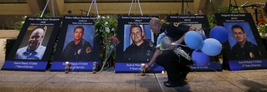 Lt. Eric Roman, of Dallas Police Honor Guard, moves a candle after a vigil hosted by the Dallas Police Association in honor of the five police officers killed by the ambush attack in the line of duty at Dallas City Hall in downtown Dallas, Monday, July 11, 2016. (Jae S. Lee/The Dallas Morning News)