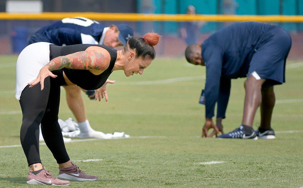 Stacey Hickman leads the Dallas Cowboys in yoga exercises at training camp in Oxnard,...