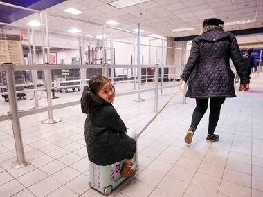 Astrid Pham, 3, of Grand Prairie, gets a ride from her grandmother Thu Pham as they head for...
