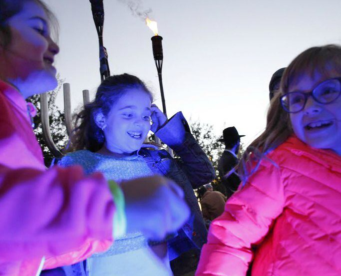 Children dance in front of the lighted Menorah during a ceremony hosted by Chabad of Frisco.