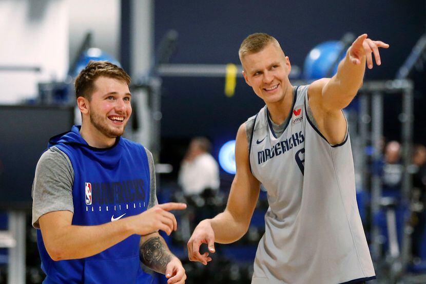 Los jugadores de los Mavericks de Dallas, Luka Doncic (izq), y Kristaps Porzingis, ríen...